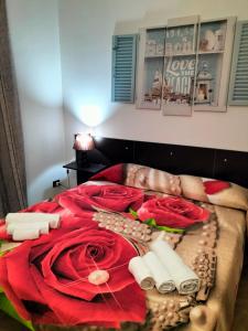 uma cama com flores vermelhas e ingredientes nela em Casa Vacanza I Due Mori em Avola