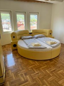 a large yellow bed in a room with windows at Apartment Alpi in Peje