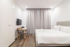 a bedroom with a bed and a table and a chair at Roots Hotel in Faro