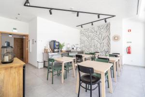 a restaurant with tables and chairs and a counter at Roots Hotel in Faro