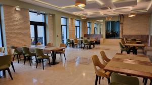 a restaurant with tables and chairs and windows at Hotel Padesul in Făget
