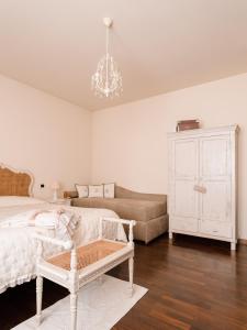 a bedroom with a bed and a couch and a chandelier at Villa Diletta b&b in Forte dei Marmi