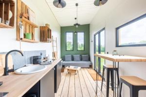 baño con lavabo y sofá en una habitación en Tiny House Centre équestre - 35 mins de Paris, en Chambly