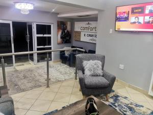 Sala de espera con silla y TV en Comfort e Casa en Kempton Park