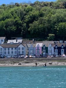 two people on the beach with houses in the background at Sea Watch Seafront Holiday House in The Mumbles