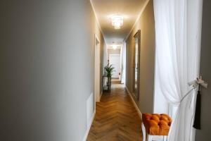 um corredor com cortinas brancas e um corredor com cadeiras laranja em Bresidence Apartments with free private parking em Ljubljana