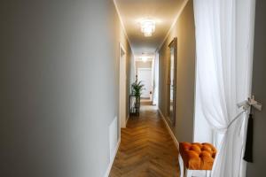 un pasillo con cortinas blancas y un pasillo con sillas naranjas en Bresidence Apartments with free private parking, en Liubliana