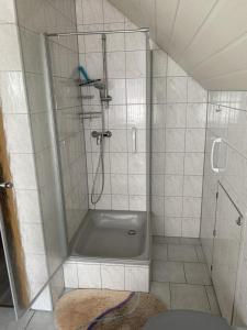 NohraにあるFerienwohnung Familie Putschkeのバスルーム(シャワー、バスタブ、トイレ付) +7枚の写真