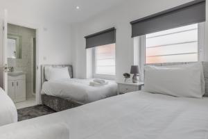 リバプールにあるRST Luxury Aparthotelの白いベッドルーム(ベッド2台、窓付)