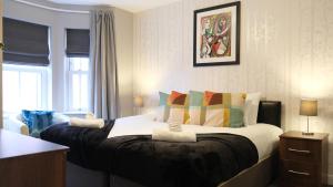 um quarto com uma cama grande e almofadas coloridas em Spacious & Contractor & Family & Private Parking & Garden em Bedford