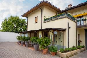 a house with potted plants in front of it at La Mimosa Lazise in Lazise
