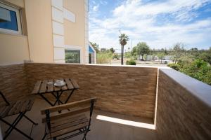 a patio with a wooden table and chairs on a brick wall at Parthenis Riviera Hotel in Athens