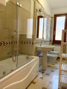 フォルテ・デイ・マルミにあるMirage Forte dei Marmiの浴槽、洗面台、トイレを備えたバスルーム +4枚の写真