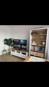 a living room with a television and a book shelf at Krasickiego 12 Gdynia Centrum in Gdynia