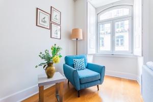 a blue chair in a living room with a window at Downtown 75 Prestige in Baixa in Lisbon