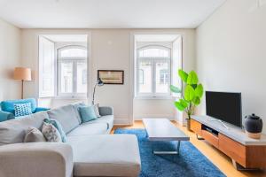 a living room with a couch and a tv at Downtown 75 Prestige in Baixa in Lisbon