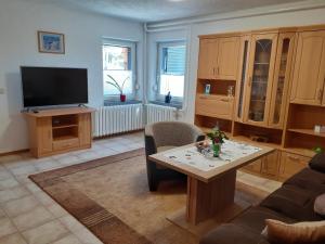 a living room with a table and a tv at Ferienwohnung Am Wald in Catterfeld