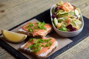a plate of food with bread and a salad and a lemon wedge at Sopot, the very heart! in Sopot +8 photos