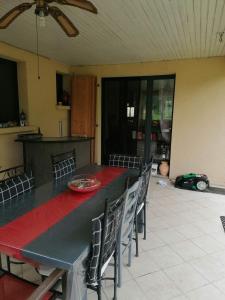 mesa de comedor con sillas y mantel rojo en Maison de campagne à Balaives et Butz, en Flize