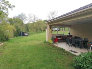 a patio with a table and chairs in a yard at Maison de campagne à Balaives et Butz in Flize