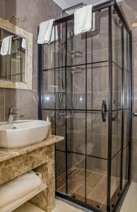 een badkamer met een glazen douche en een wastafel bij THE LEA HOTELS & SUITE in Didim