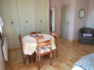 a dining room with a table and chairs and a couch at Résidence Lou Cigaloun - ANA LOCATION in Gréoux-les-Bains