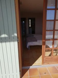 a view of a bedroom through a glass door at Résidence Lou Cigaloun - ANA LOCATION in Gréoux-les-Bains