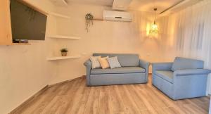 a living room with two blue chairs and a flat screen tv at Dor on the beach in Dor