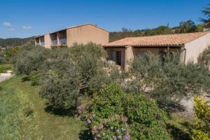 a house on a hill with bushes in front of it at Résidence Lou Cigaloun - ANA LOCATION in Gréoux-les-Bains