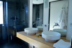 un bagno con due lavandini e una doccia in vetro di Hameau de Pichovet a Vachères
