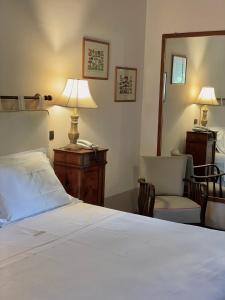 a bedroom with a bed and a desk and a mirror at Tenuta di Santa Lucia in Soriano nel Cimino