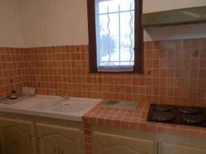 a kitchen with a sink and a stove and a window at Résidence Lou Cigaloun - ANA LOCATION in Gréoux-les-Bains