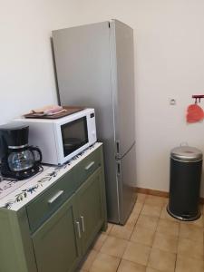 a kitchen with a microwave and a refrigerator at Résidence Lou Cigaloun - ANA LOCATION in Gréoux-les-Bains