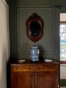 a vase sitting on a wooden dresser with a mirror at Tenuta di Santa Lucia in Soriano nel Cimino