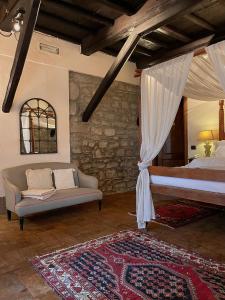 ソリアーノ・ネル・チミーノにあるTenuta di Santa Luciaのベッドルーム1室(ベッド1台、ソファ付)