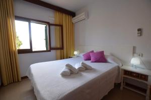 a bedroom with a large white bed with purple pillows at Zodiac 1. in Alcudia +12 photos