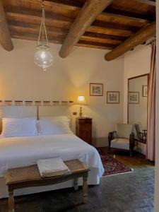 a bedroom with a large white bed and a chair at Tenuta di Santa Lucia in Soriano nel Cimino