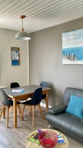 ein Wohnzimmer mit einem Tisch und einem Sofa in der Unterkunft La Tranquille - Maison pour 3 familles in La Michelière