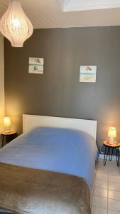 ein Schlafzimmer mit einem blauen Bett und zwei Nachttischen in der Unterkunft La Tranquille - Maison pour 3 familles in La Michelière
