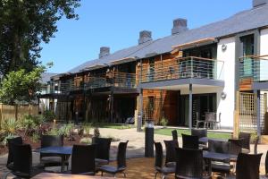 ein Gebäude mit Tischen und Stühlen davor in der Unterkunft Les Ormes Resort in St Brelade