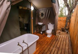 ein Badezimmer mit einer Badewanne und einem WC in einem Zelt in der Unterkunft Nature's Loft in Fouriesburg