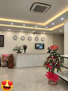 a lobby with a christmas tree and clocks on the wall at Tuấn Đạt Luxury FLC Sầm Sơn in Sầm Sơn +54 photos