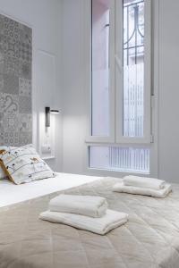 um quarto branco com uma cama com duas toalhas em Room close to City Centre em Valência