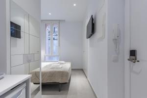 Habitación blanca pequeña con cama y ventana en Room close to City Centre, en Valencia