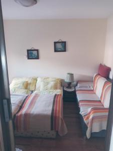 ハイドゥソボスローにあるOlga Apartmanházのベッドルーム1室(ベッド2台付)、壁にランプが備わります。
