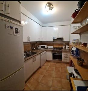 una grande cucina con armadietti e elettrodomestici bianchi di Retiro Mar y Montaña a Castellón de la Plana Altre 19 foto