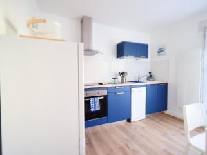 uma cozinha com armários azuis e balcões azuis em ROCHAMBEAU - Moderne - Face aux Thermes - Parking - em Vichy