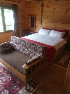 a bedroom with a bed and a bench in a cabin at panoramabungalov in Çamlıhemşin