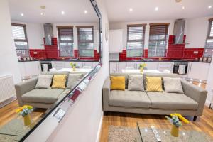 a living room with two couches and a staircase at Modern apartment close to city centre with parking in Leeds