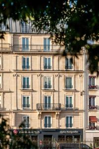 - un grand bâtiment avec des balcons sur le côté dans l'établissement Best Western Plus Opéra Batignolles, à Paris